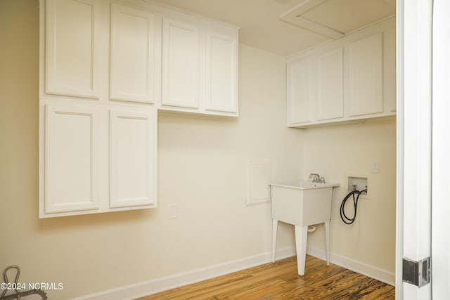 laundry room with cabinet space, attic access, baseboards, wood finished floors, and hookup for a washing machine