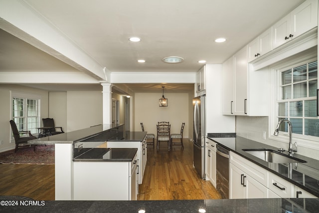 kitchen featuring appliances with stainless steel finishes, dark wood-style flooring, white cabinetry, and a sink