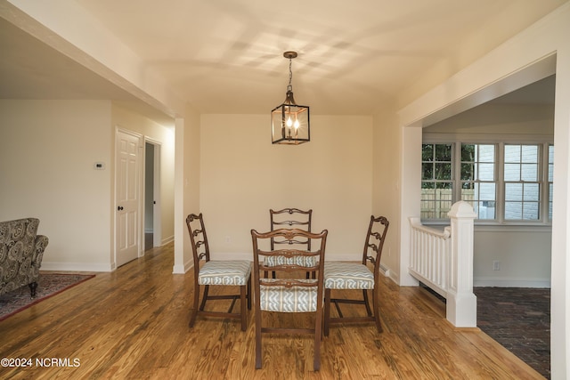 dining room featuring an inviting chandelier, baseboards, and wood finished floors