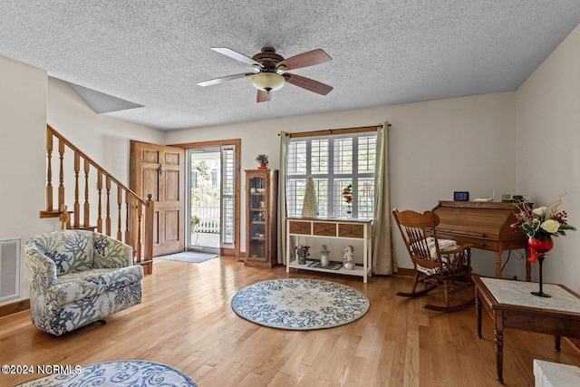 entrance foyer featuring ceiling fan, a textured ceiling, and light hardwood / wood-style flooring