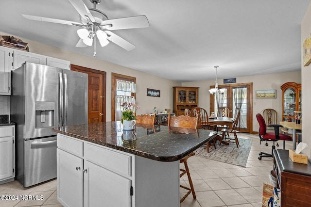 kitchen with a healthy amount of sunlight, ceiling fan, white cabinetry, and stainless steel refrigerator with ice dispenser