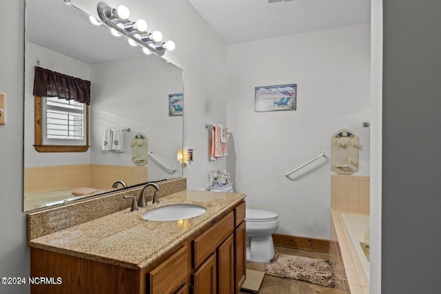 bathroom featuring toilet, a tub, tile patterned floors, vanity, and a textured ceiling