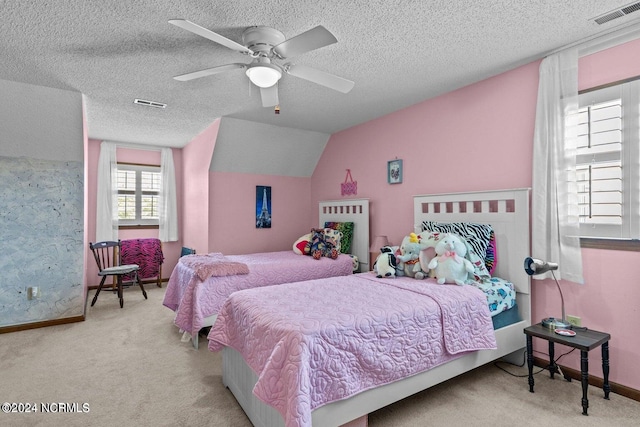 bedroom with lofted ceiling, ceiling fan, light colored carpet, and a textured ceiling