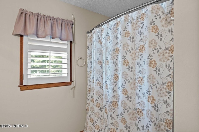 bathroom featuring a textured ceiling and walk in shower