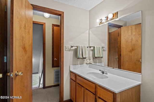 bathroom with a textured ceiling and vanity