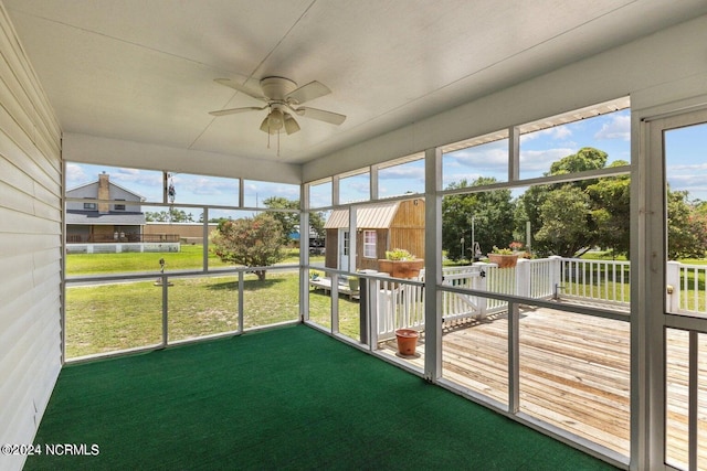 unfurnished sunroom featuring ceiling fan