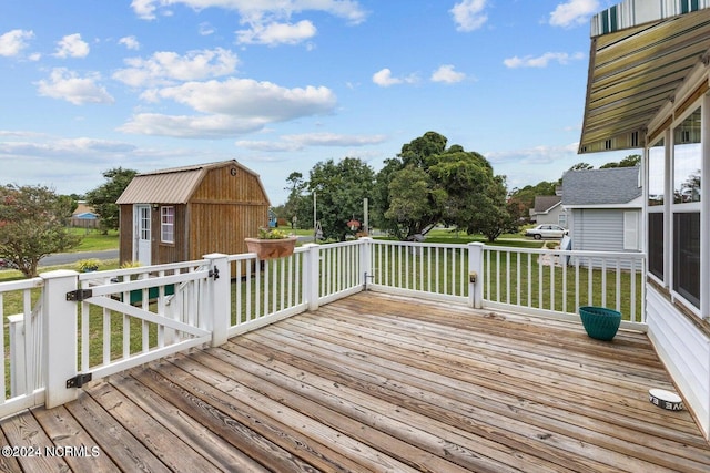 wooden terrace featuring a yard and a shed