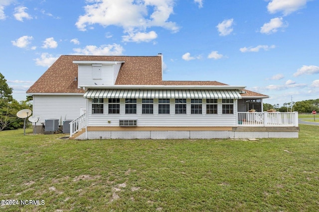 rear view of house with a wooden deck, a yard, and central AC