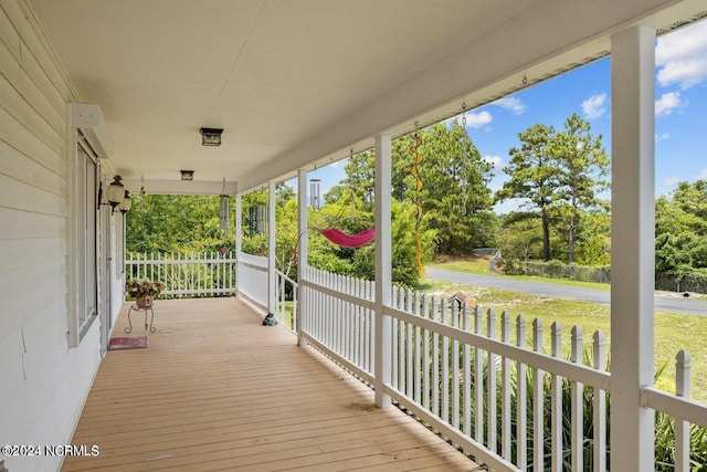 wooden terrace with a yard and covered porch