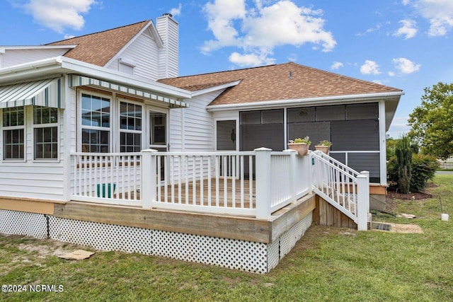 back of house with a lawn, a sunroom, and a deck