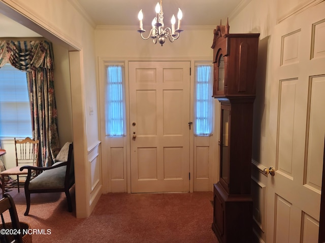 foyer entrance featuring carpet floors, crown molding, and an inviting chandelier