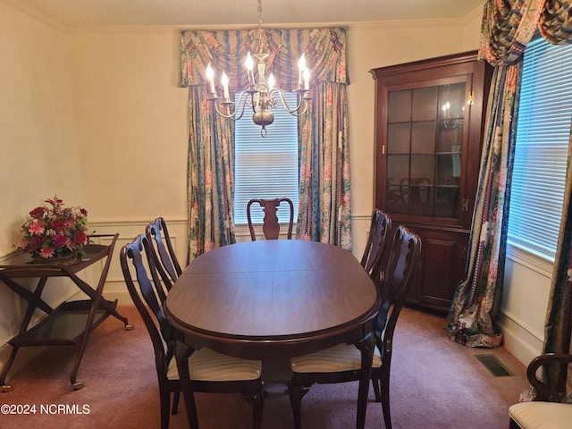 dining space with carpet floors, a notable chandelier, and ornamental molding