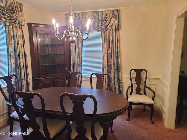 dining area with carpet flooring, an inviting chandelier, and crown molding