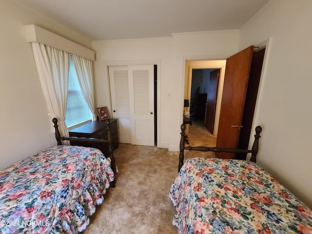 bedroom featuring crown molding, a closet, and light colored carpet