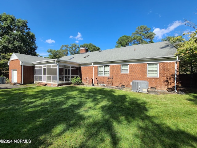 rear view of property with a lawn, a sunroom, and cooling unit