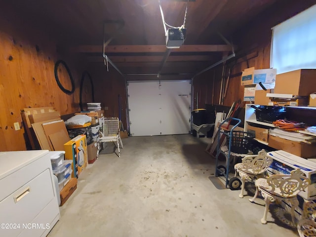 garage featuring a garage door opener and wooden walls