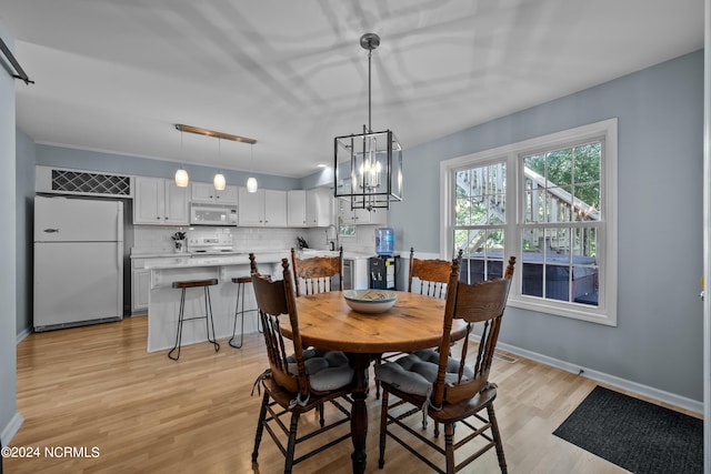 dining space featuring a chandelier, light hardwood / wood-style floors, and sink