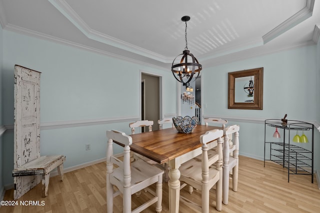 dining space with light wood-type flooring, an inviting chandelier, and ornamental molding