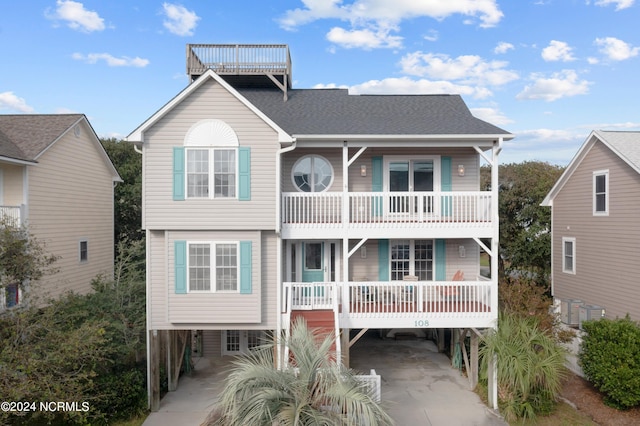 view of front of home with a balcony, a porch, and a carport