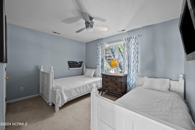 carpeted bedroom with a textured ceiling and ceiling fan