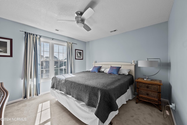 carpeted bedroom with a textured ceiling and ceiling fan