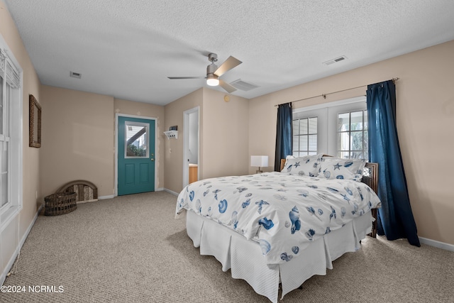 carpeted bedroom with a textured ceiling and ceiling fan