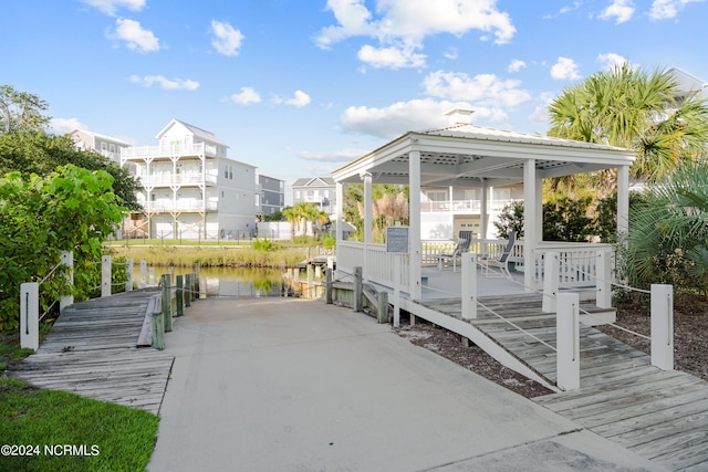 view of community featuring a water view, a gazebo, and a dock