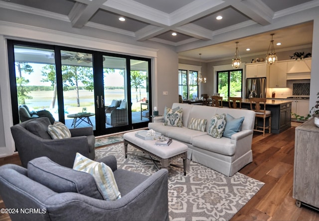 living room featuring crown molding, hardwood / wood-style floors, a chandelier, and coffered ceiling