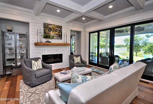 living room featuring ornamental molding, coffered ceiling, hardwood / wood-style flooring, beamed ceiling, and a fireplace