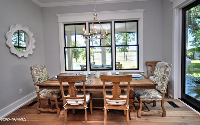 dining area with hardwood / wood-style flooring, a healthy amount of sunlight, and crown molding