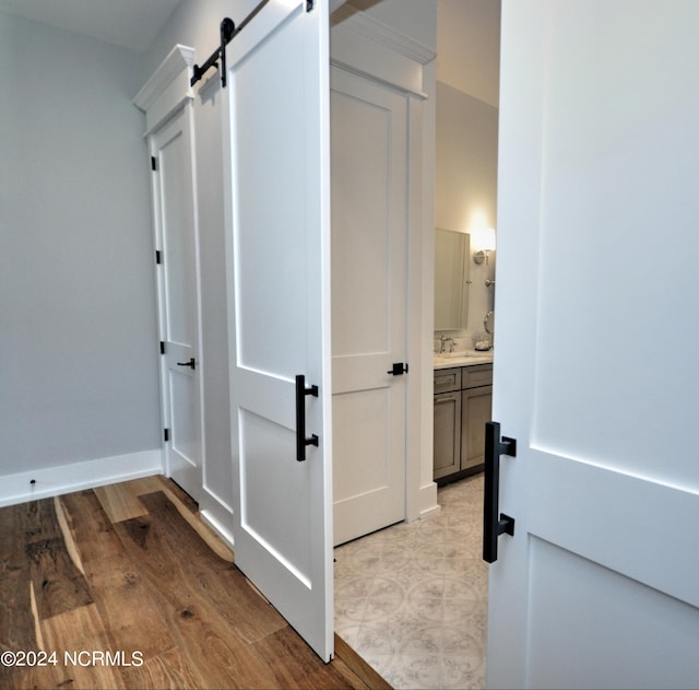 hall featuring a barn door, sink, and light wood-type flooring