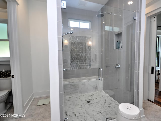 bathroom with tile patterned floors, toilet, and a shower with shower door