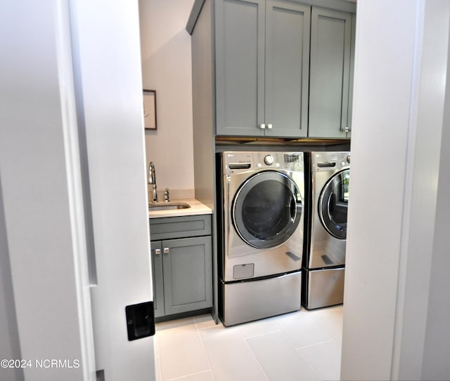 washroom featuring cabinets, sink, light tile patterned floors, and washer and dryer