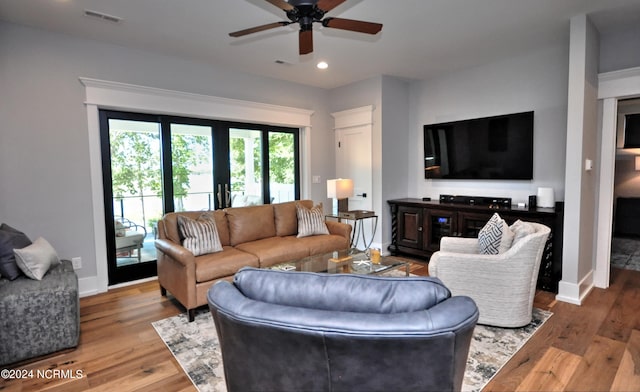 living room featuring french doors, light hardwood / wood-style flooring, and ceiling fan