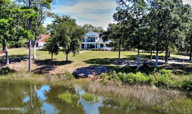 surrounding community with a water view and a lawn