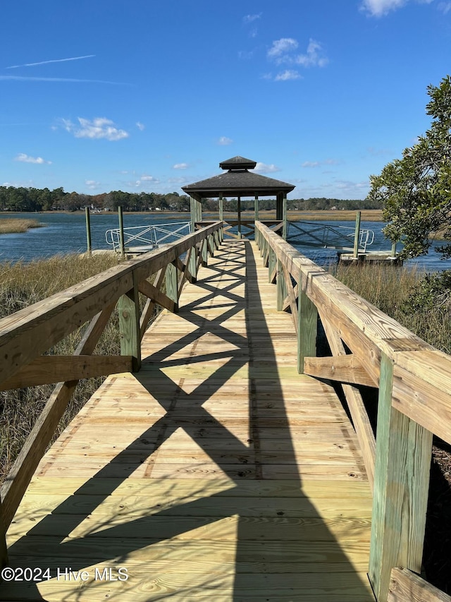 view of dock with a gazebo and a water view