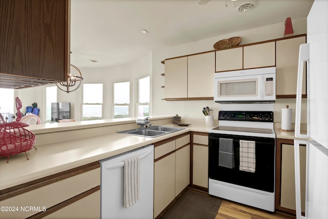 kitchen featuring white appliances, visible vents, cream cabinets, light countertops, and a sink