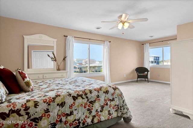 bedroom with baseboards, multiple windows, visible vents, and light colored carpet