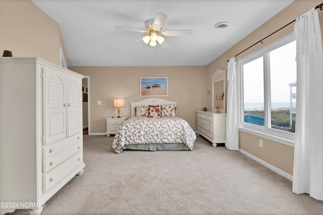 bedroom featuring baseboards, visible vents, a ceiling fan, and light colored carpet