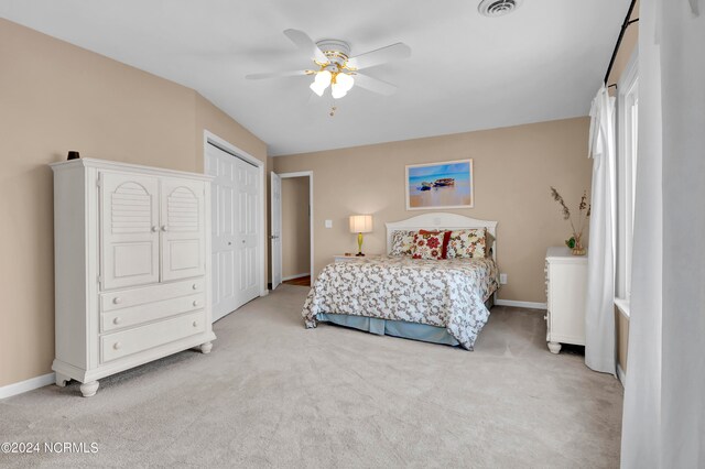 bedroom featuring visible vents, baseboards, light colored carpet, ceiling fan, and a closet