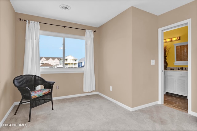 living area featuring carpet flooring, visible vents, and baseboards