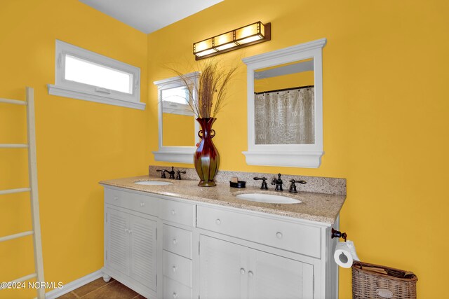 full bathroom featuring a sink and double vanity