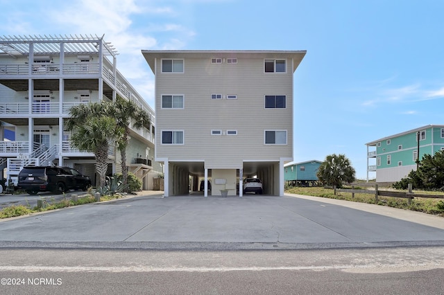 view of property with driveway and a carport