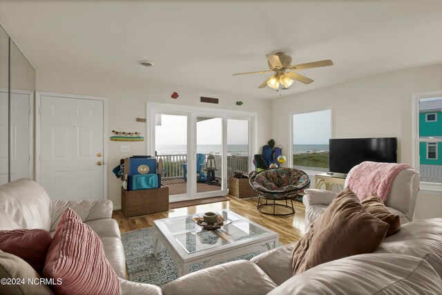 living area with ceiling fan, visible vents, and wood finished floors