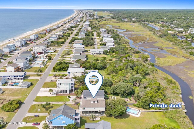 birds eye view of property with a water view and a beach view