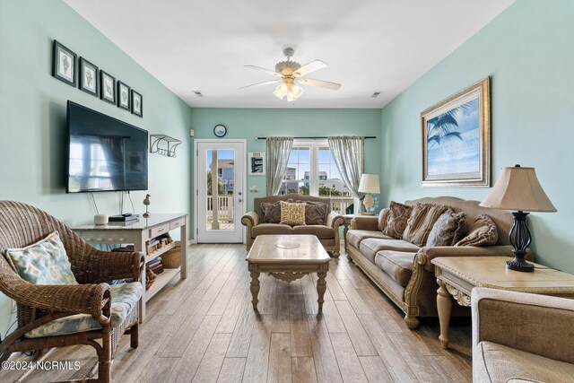 living room with light hardwood / wood-style floors and ceiling fan