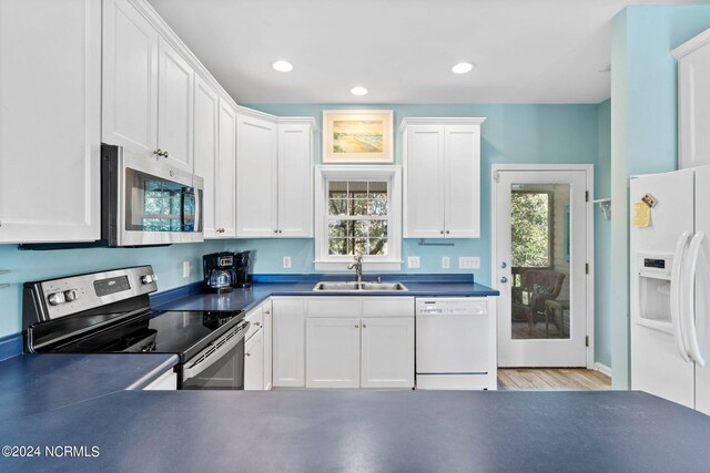 kitchen featuring sink, appliances with stainless steel finishes, white cabinetry, and a healthy amount of sunlight