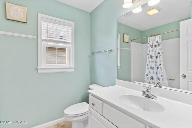 bathroom with curtained shower, tile patterned flooring, vanity, and toilet