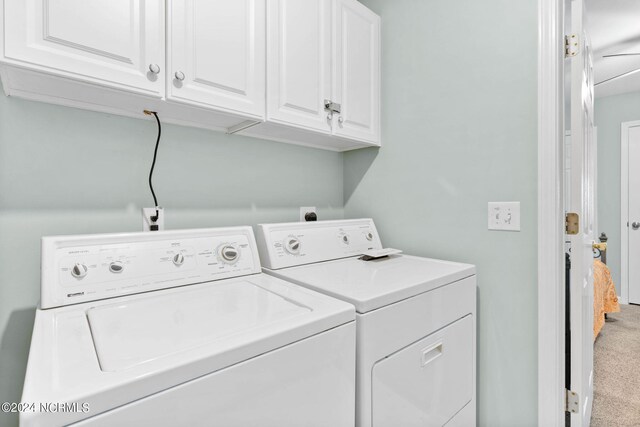 laundry room featuring carpet floors, independent washer and dryer, and cabinets