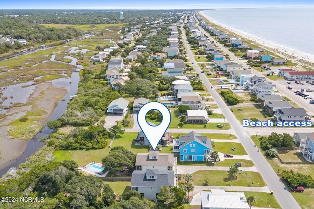 birds eye view of property featuring a beach view and a water view